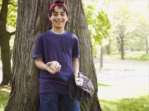 Smiling mixed race boy holding baseball and glove