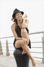 Mixed race woman sitting on pier