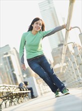 Mixed race woman on pier holding railing