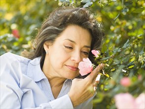 Caucasian woman smelling flower outdoors