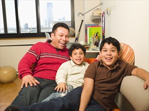 Hispanic father and sons laughing