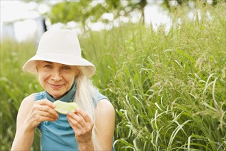 Smiling Caucasian woman eating in grass