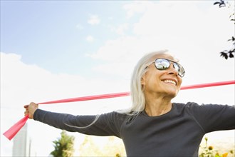 Smiling Caucasian woman stretching with resistance band