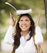 Hispanic woman balancing book on her head