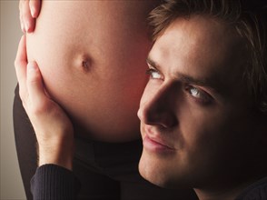 Husband listening to pregnant wife's stomach