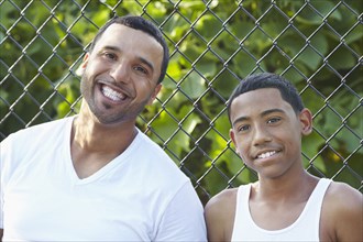 Hispanic father and son smiling outdoors