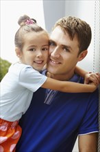 Smiling father holding daughter