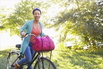 Black woman riding bicycle outdoors