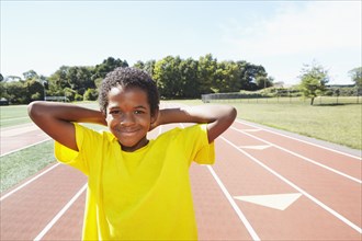 Mixed race boy smiling on track