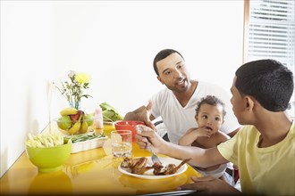 Hispanic father and children eating together