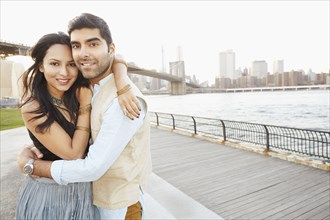 Indian couple hugging by New York city skyline
