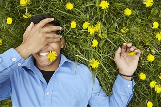 Smiling man laying in field of flowers