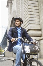 Smiling man riding bicycle on city street