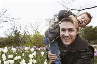 Father carrying son in park