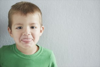 Close up of mixed race boy sticking out tongue