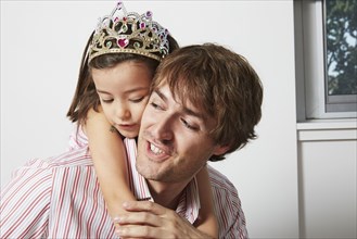 Father carrying daughter in tiara