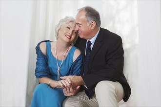 Smiling older couple in formal wear hugging