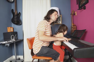 Father and daughter playing piano