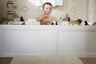 Caucasian boy playing in bathtub
