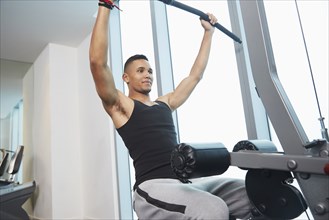 Black man using exercise machine in gym