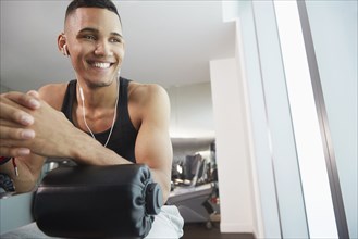 Black man smiling on exercise machine in gym