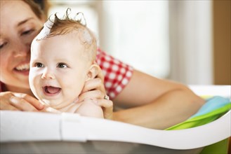 Caucasian mother bathing baby daughter