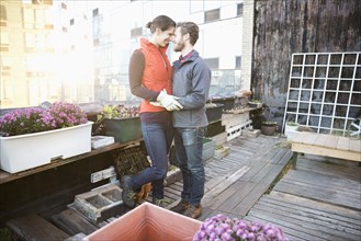 Couple hugging in urban rooftop garden