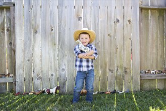Caucasian boy wearing cowboy hat hugging toy horse