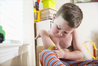 Caucasian boy examining adhesive bandage on elbow