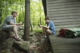 Caucasian father and son reading books at cabin