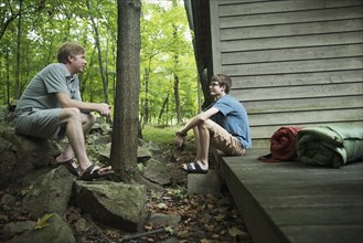Caucasian father and son talking at cabin