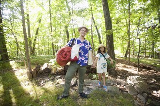 Caucasian father and daughter carrying bags at cabin