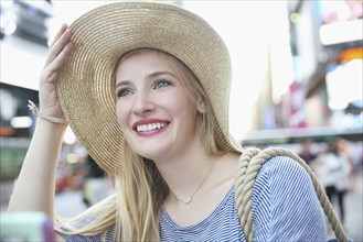 Portrait of smiling Caucasian woman wearing hat in city