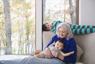 Smiling grandmother and grandsons near window