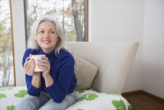 Portrait of smiling Caucasian woman drinking coffee