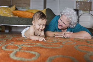 Grandmother and grandson laying on carpet