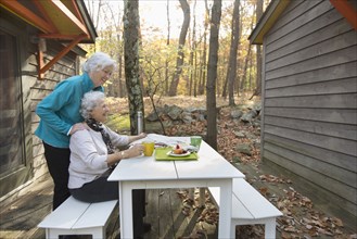 Caucasian women enjoying breakfast outdoors near cabin
