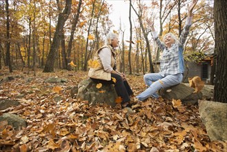 Caucasian women playing with autumn leaves