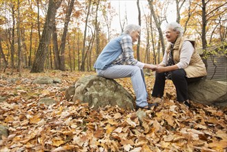 Caucasian women holding hands outdoors in autumn