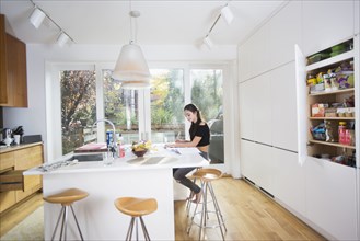 Caucasian girl doing homework in domestic kitchen
