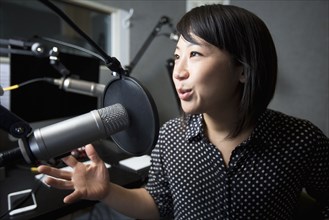 Asian woman talking into microphone