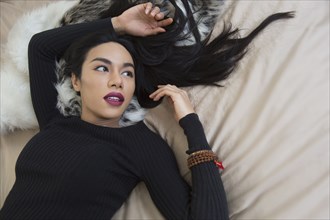 Glamorous transgender Thai woman laying on bed