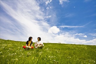 Asian couple playing drums in meadow