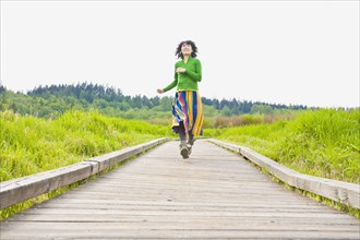 Asian woman running on wooden path