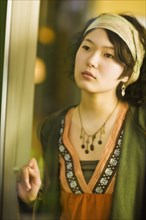 Asian woman looking out window