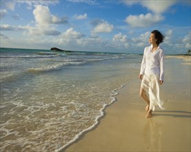 Asian woman walking on beach