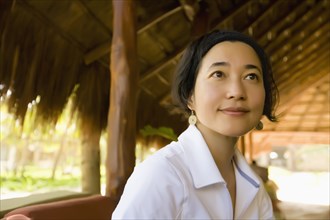 Asian woman sitting in hut