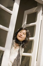 Japanese woman looking out french doors