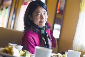 Asian woman eating in diner