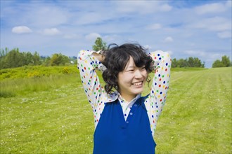 Happy Asian woman standing in park